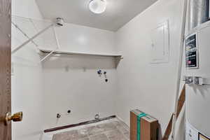 Laundry area with water heater, gas dryer hookup, washer hookup, and electric panel