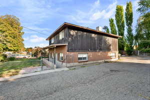View of side of home featuring brick siding and a gate
