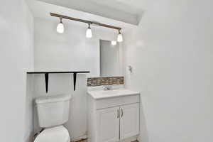 Bathroom with backsplash, vanity, and rail lighting