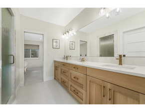 Full bath with double vanity, a stall shower, connected bathroom, and light tile patterned floors Jack & Jill Bath 4 Between beds 4-5