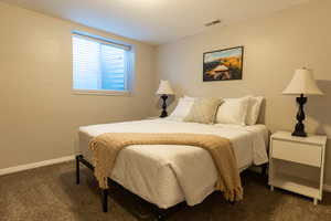 Bedroom with dark carpet and baseboards
