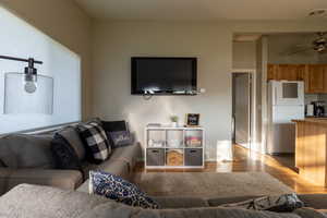 Living room with light wood-style flooring and a ceiling fan