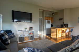 Living room with light wood-type flooring and ceiling fan