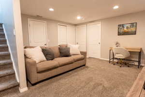 Living area featuring stairs, carpet floors, and recessed lighting