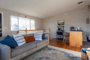 Living area with dark wood-style floors and a ceiling fan