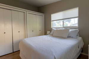 Bedroom with two closets and wood finished floors