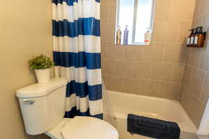 Bathroom with shower / tub combo and toilet