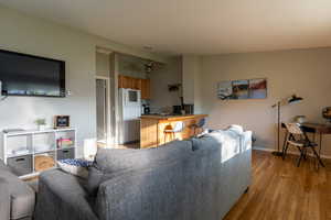 Living area featuring light wood finished floors, a ceiling fan, and an office area