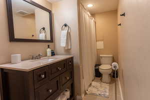 Full bathroom with vanity, light tile patterned floors, and a shower with curtain