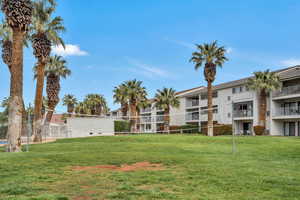 View of community with volleyball court and a lawn