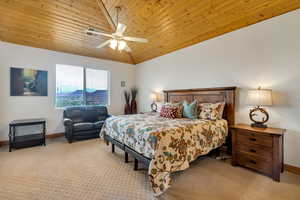 Bedroom with carpet, wood ceiling, vaulted ceiling, and ceiling fan