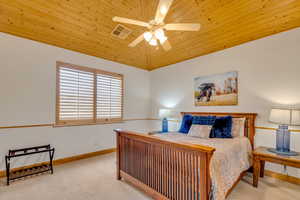 Bedroom featuring light carpet, wood ceiling, vaulted ceiling, and a ceiling fan