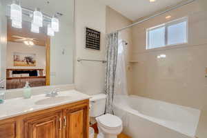 Bathroom with shower / bath combination with curtain, vanity, and ceiling fan