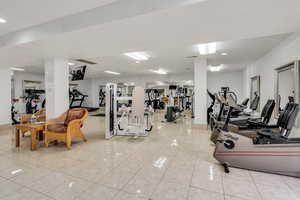 Exercise room featuring light tile patterned flooring and recessed lighting