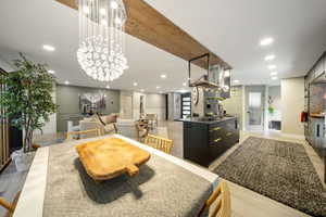 Dining room featuring a chandelier, recessed lighting, a decorative wall, and light wood-style flooring
