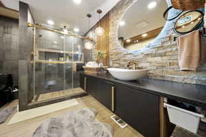 Full bathroom featuring vanity, a stall shower, light wood finished floors, and recessed lighting