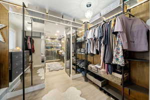 Walk in closet with light wood-style floors