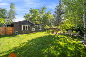 Fenced backyard featuring a sunroom