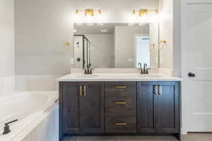 Full bathroom featuring double vanity, a garden tub, a shower stall, and light tile patterned floors