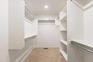 Walk in closet featuring light carpet