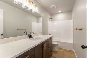 Bathroom featuring vanity, light wood-style flooring, and shower / bathtub combination