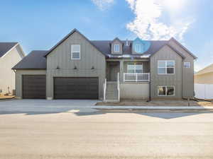 View of front of property featuring a porch, board and batten siding, a garage, driveway, and a shingled roof