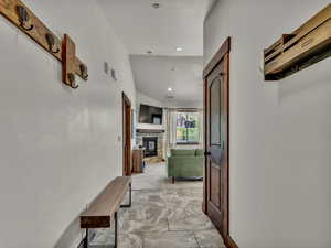 Corridor with vaulted ceiling, recessed lighting, and light colored carpet