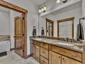 Full bath with a garden tub, double vanity, and a walk in closet