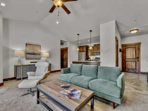 Living area with recessed lighting, light carpet, lofted ceiling, and a ceiling fan