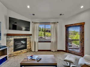 Living room with carpet flooring, recessed lighting, and a fireplace