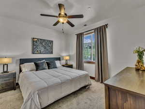Bedroom with light colored carpet and ceiling fan