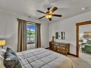 Carpeted bedroom featuring a ceiling fan and baseboards