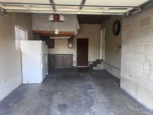 Garage with freestanding refrigerator and a garage door opener