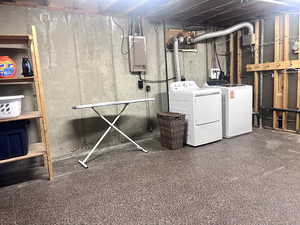 Unfinished basement with electric panel and washing machine and clothes dryer