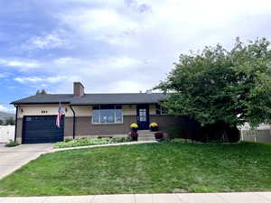 Ranch-style house featuring a chimney, brick siding, a garage, concrete driveway, and a shingled roof