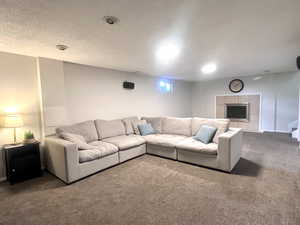Living area with carpet, a tile fireplace, and a textured ceiling