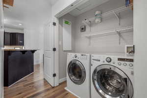 Washroom featuring dark wood-style flooring, washer and clothes dryer, and a textured ceiling