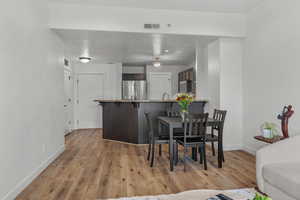 Dining area featuring light wood-style flooring and baseboards