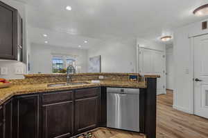Kitchen featuring dark brown cabinetry, dishwasher, a peninsula, recessed lighting, and light wood finished floors