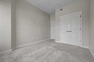 Unfurnished bedroom with carpet flooring and a closet