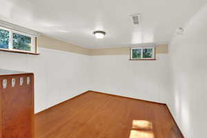 Basement bedroom featuring hard wood floors with a built in dresser