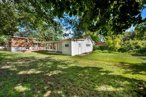 View of green lawn with a patio area