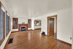 Living room with hard  wood floors, arched walkways, and a brick fireplace