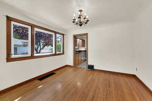 Dining  area featuring plenty of natural light   and hard wood floors and a chandelier