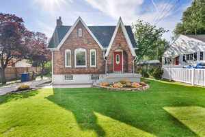 English style home featuring brick siding and a chimney