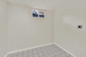 Laundry area with hookup for an electric dryer and tile floor