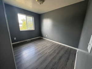 Spare room with wood finished floors and a textured ceiling