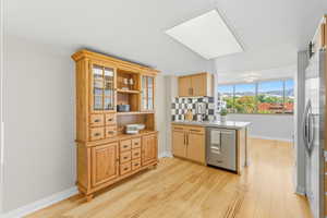 Kitchen area with stainless steel appliances, open shelves, light wood-style floors, and a mountain view