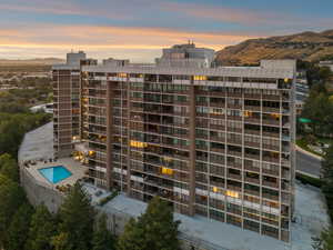 Property at dusk with a mountain view and a view of apartment building / complex