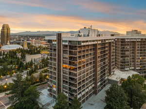Property at dusk featuring a mountain view, a view of apartment building / complex, and a city view